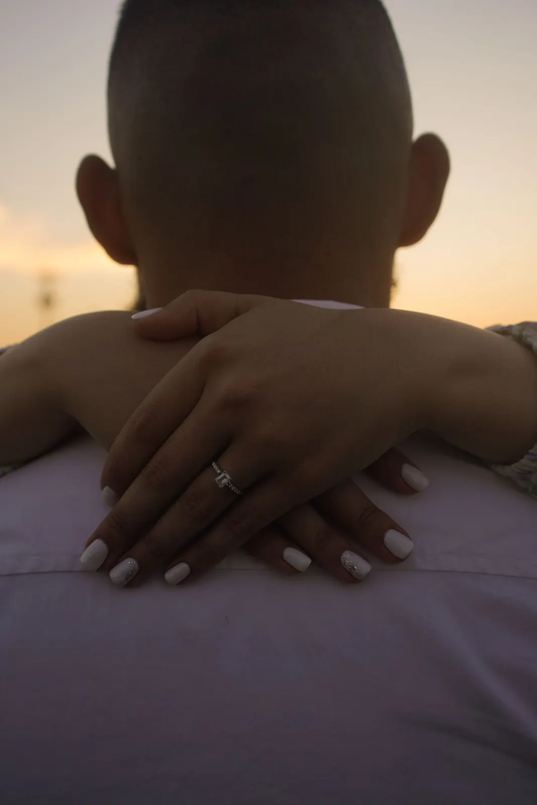 Couple hugging with an engagement ring visible (sample image)