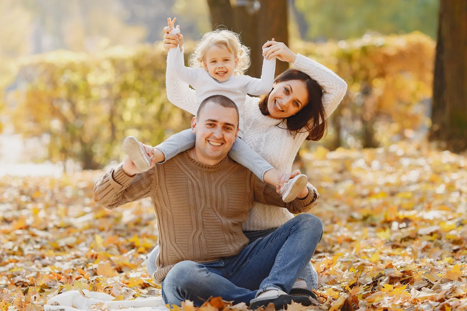 Parents with a toddler among autumn leaves (sample image)