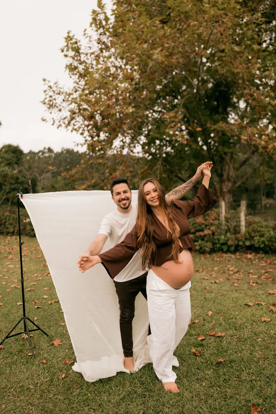 Expectant couple laughing at an outdoor maternity shoot (sample image)