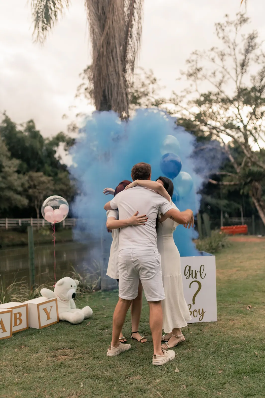 Couple hugging in blue smoke at a gender reveal (sample image)