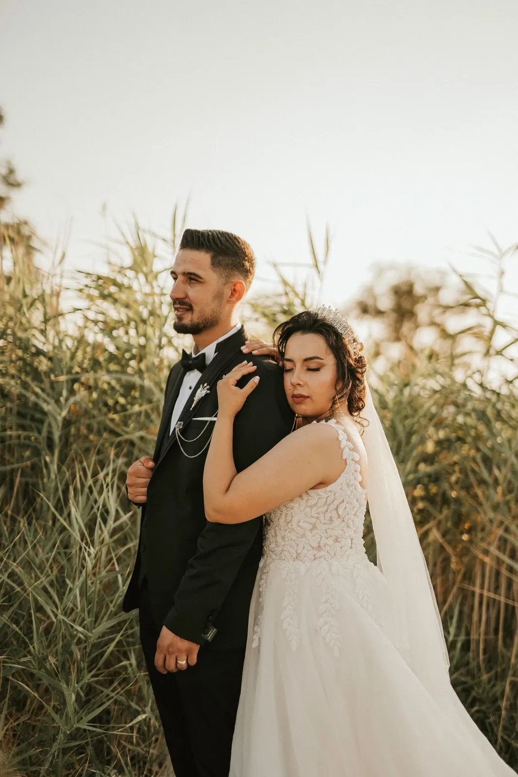 Couple among tall grass on their wedding day (sample image)